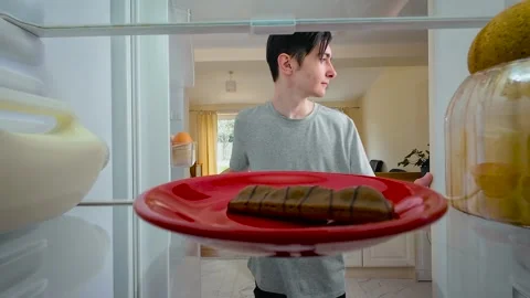 Boy opening fridge, looking at chocolate bar, glancing around and quickly taking Stock Footage 328370570