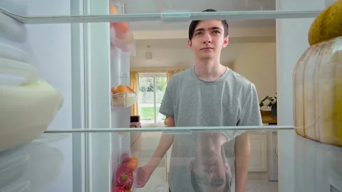 Boy opening fridge, looking inside and sighing melancholically, view from inside Stock Footage 309021542