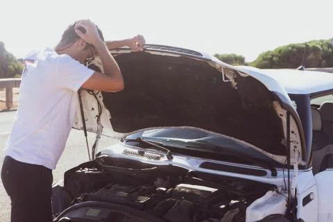 Boy opening the hood of his white car Stock Photos