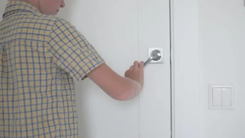 The boy opens and closes the door to the room Stock Footage 136224290