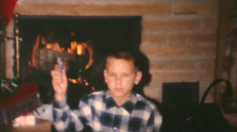 Boy Opens Christmas Gift By Fireplace-1962 Vintage 8mm film Stock Footage 66363876