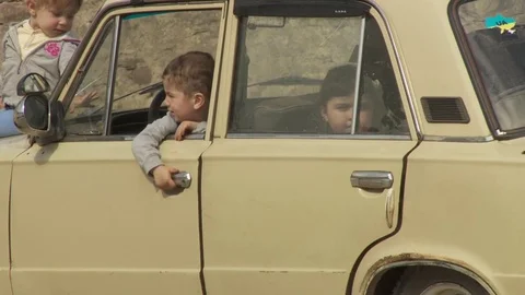 The boy opens the door of the old machine and sit with your sister. a big family Stock-Footage 69982102