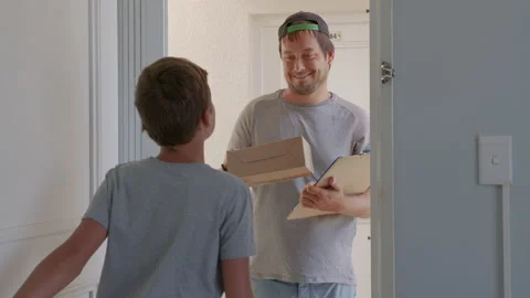 Boy Opens Doors of his House and Meets Delivery Man who Gives His Cardboard Box Stock Footage 150282809