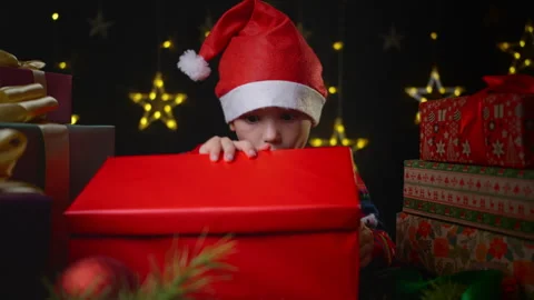 A boy opens a gift for Christmas or New Year. Video stock 253829064