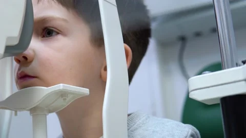 A boy in an ophthalmology clinic performs a vision test on special equipment Video stock 150151160