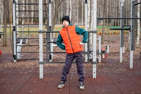 Boy in orange vest performing side bends to train oblique muscles during ou.. Stock Photos