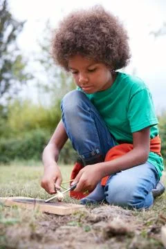 Boy On Outdoor Camping Trip Learning How To Make Fire Stock Photos