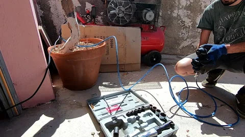 Boy outdoors testing a pneumatic gun with air compressor and sets of heads Video stock 171863428