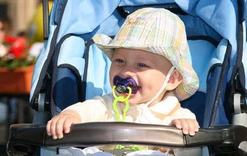 Boy with pacifier in stroller Stock Photos