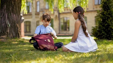 Boy packing backpack while sitting outdoors Stock Footage 127800965