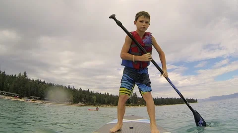 Boy on paddle board on lake Stock Footage 62394495
