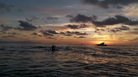 Boy paddling on his paddle while the sun sets Stock Footage 135745077
