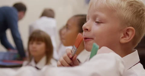 Boy with paintbrush in classroom Stock Footage 58573006