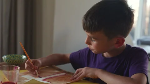 Boy painting cross artwork for first communion - pull out dynamic shot Stock Footage 281774949