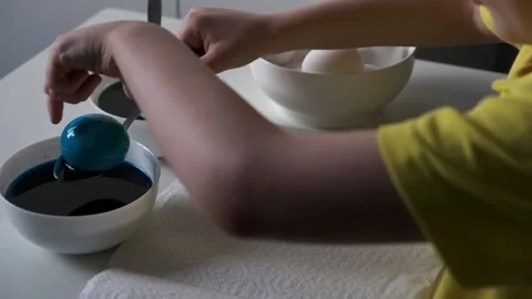 A boy painting an Easter egg on a white table. Colorful easter eggs. Easter Stock Footage 231818867