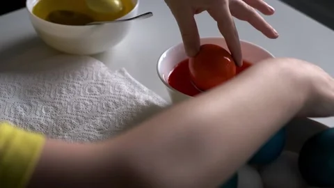 A boy painting an Easter egg on a white table. Colorful easter eggs. Easter Stock Footage 231818871