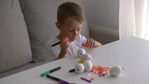 Boy Painting Easter Eggs with Marker During Home Craft Activity 스톡 동영상 330466477