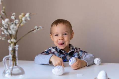 The boy paints decorative eggs for Easter with felt-tip pens Stock Photos