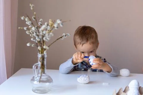 The boy paints decorative eggs for Easter with felt-tip pens Foto stock