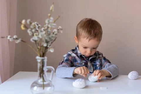 The boy paints decorative eggs for Easter with felt-tip pens Foto stock