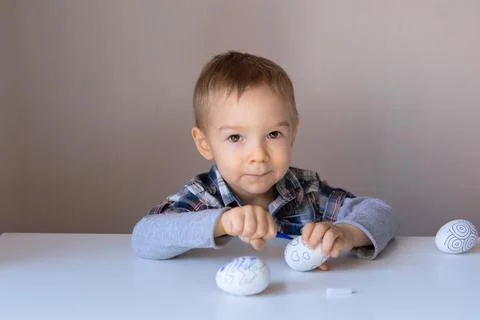 The boy paints decorative eggs for Easter with felt-tip pens Foto stock