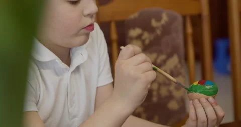 A boy paints an Easter egg with a brush Stock Footage 172202839