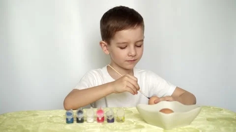 A boy paints Easter eggs and prepares to celebrate Easter Video stock 151006931