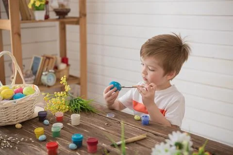 A boy paints Easter eggs and prepares to celebrate Easter Stock Photos