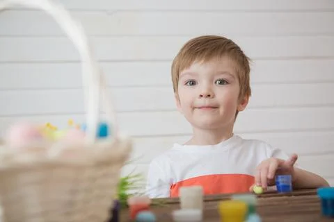 A boy paints Easter eggs and prepares to celebrate Easter 스톡 사진