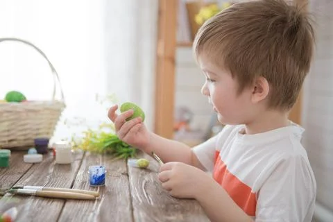 A boy paints Easter eggs and prepares to celebrate Easter Foto stock