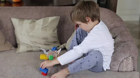 Boy in Pajamas Playing in the Constructor on the Couch Video stock 68312236
