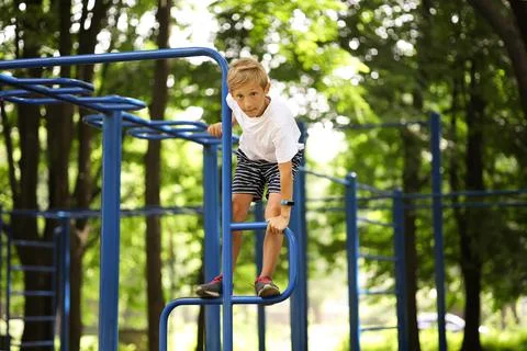 Boy in the park on horizontal bars Fotos Stock