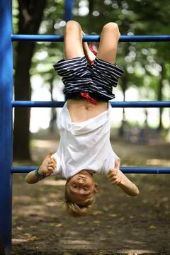 Boy in the park on horizontal bars Stock Photos