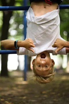 Boy in the park on horizontal bars Stock Photos