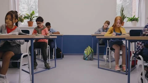 Boy passing a note to a girl at the classroom. Love notes at elementary school Video stock 162737984