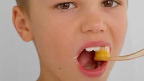 The boy is performing dental hygiene. Video stock 278510087
