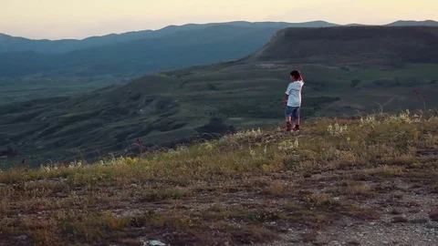 The boy performs dance moves against the background of the mountains Stock Footage 76469909