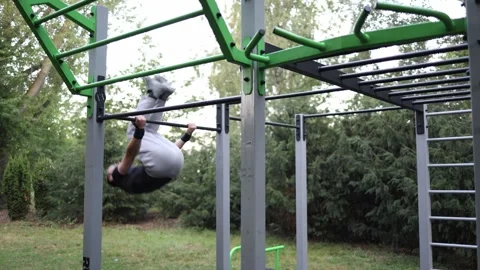 Boy performs front lever holding his body straight and parallel to ground on out Stock Footage 316701642
