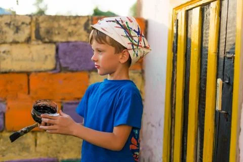 Boy performs painting works paint outdoors summer Stock Photos