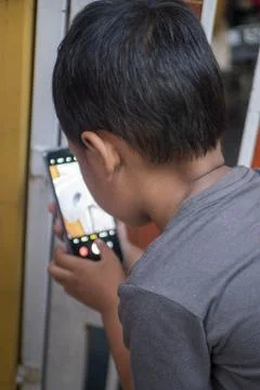 Boy is photographing the gate of the house using a smartphone Stock Photos