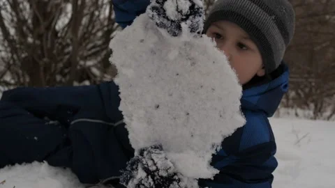 The boy picks up a block of ice and breaks it with his hand as if in a fight Stock Footage 146155799