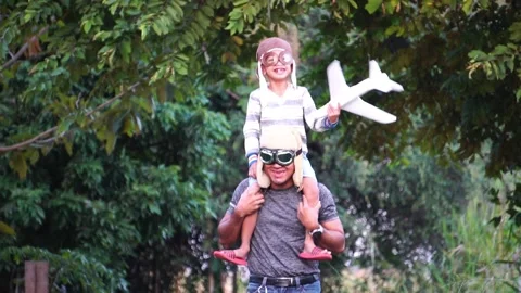 Boy with pilot glasses play fly with his dad at park Stock Footage 220555986