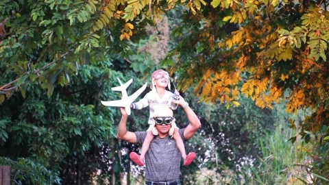 Boy with pilot glasses play fly with his dad at park Stock Footage 220555989
