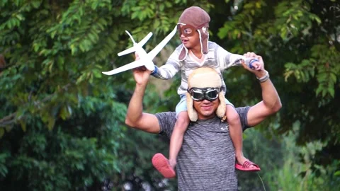 Boy with pilot glasses play fly with his dad at park Stock Footage 220556017