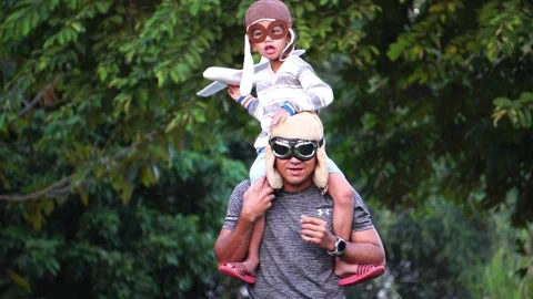 Boy with pilot glasses play fly with his dad at park Stock Footage 220556103