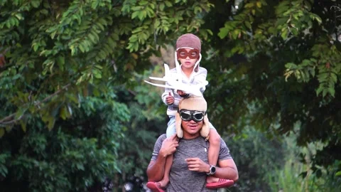 Boy with pilot glasses play fly with his dad at park Stock Footage 220556110
