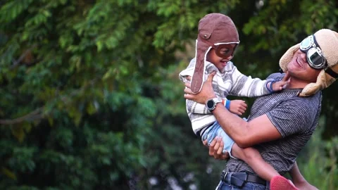Boy with pilot glasses play fly with his dad at park 動画素材 220556359