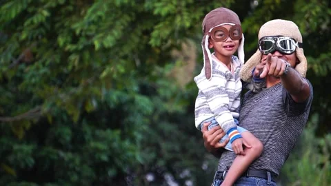 Boy with pilot glasses play fly with his dad at park Видео 220556530