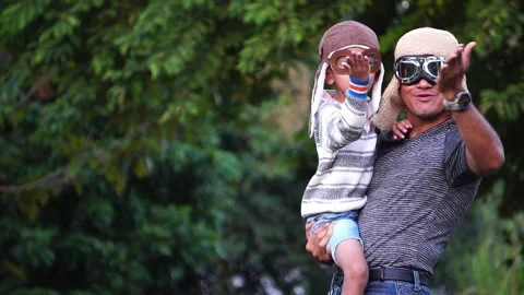 Boy with pilot glasses play fly with his dad at park Stock Footage 220556565