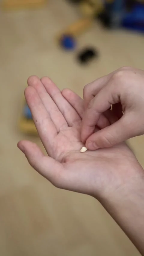 Boy places his lost milk tooth into his open palm Stock Footage 340516197